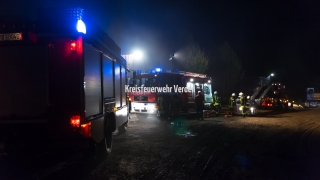 Einsatzkräfte bereiten den Innenangriff unter Atemschutz sowie eine Drehleiter für Löscharbeiten von außen vor.