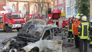 Ausgebrannter PKW, Einsatzkräfte vor Ort.