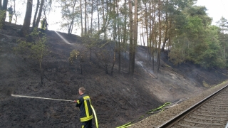 Löscharbeiten an einem Bahndamm.