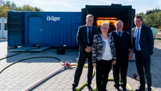 Erste Kreisrätin Regina Tryta (Mitte links) und Kreisbrandmeister Hans-Hermann Fehling (Mitte rechts) mit Vertretern der Firma Dräger vor der Realbrandausbildungsanlage.
