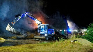 Mit einem Bagger sowie Radlader wurde das glimmende Stroh aus der Lagerhalle auf einer angrenzenden Wiese ausgebracht und endgültig abgelöscht.