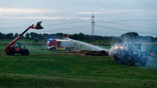 Mit einem Bagger sowie Radlader wurde das glimmende Stroh aus der Lagerhalle auf einer angrenzenden Wiese ausgebracht und endgültig abgelöscht.