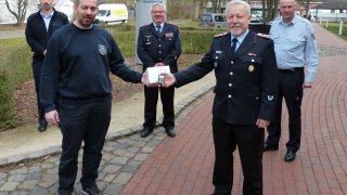 Leitstellen-Mitarbeiter Stefan Harries (vorne links) überreicht den letzten Melder symbolisch an Dörverdens Gemeindebrandmeister Andreas Thölke. Im Hintergrund stehen (von links) der stellvertretende Leitstellenleiter Ralf Wiechers, Kreisbrandmeister Hans-Herrmann Fehling und Leitstellenleiter Günter Storch.