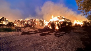 Lage bei Eintreffen der Einsatzkräfte – etliche Rundballen stehen in Vollbrand.