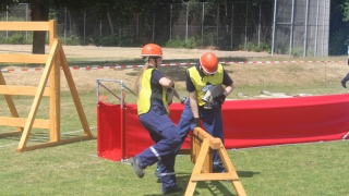 Der Schlauchtrupp beim Überwinden der Hürde