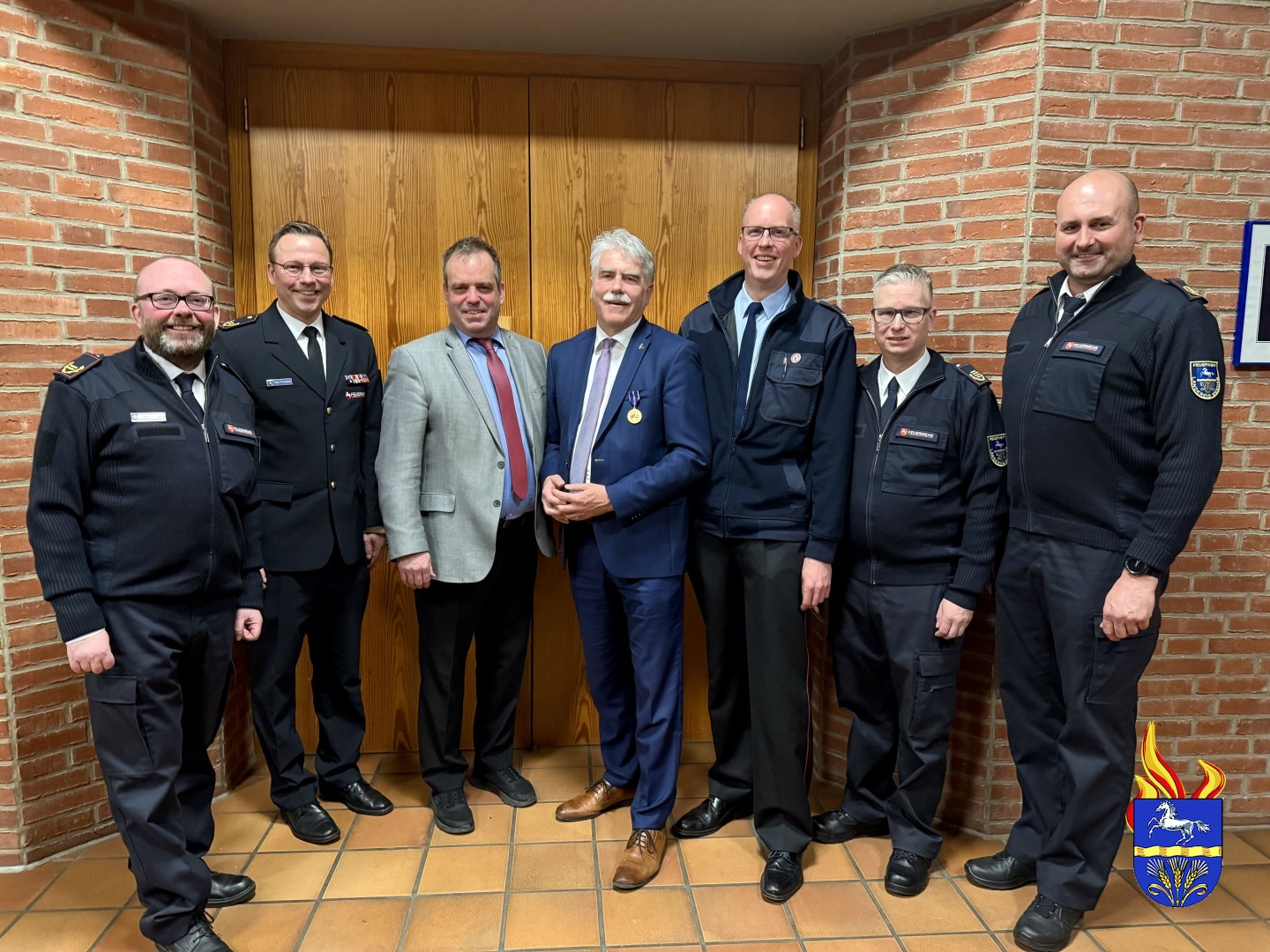 Zur Ehrung gratulieren Bürgermeister Lutz Brockmann (Mitte) und Dirk Wilkens (Mitte rechts) Kreisbrandmeister Dennis Körte, Regierungsbrandmeister Tim Fritsche, Landrat Peter Bohlmann, stellvertretender Kreisbrandmeister Ulf Carstens und stellvertretender Kreisbrandmeister Mario Rosebrock (v.l.).