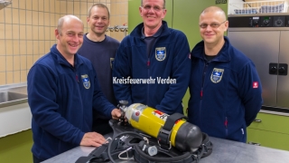 Vier der AGT-Ausbilder vor einem Atemschutzgerät.